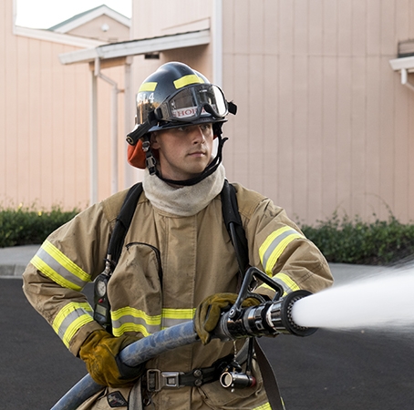 Firefighter demonstrates the use of a fire hose